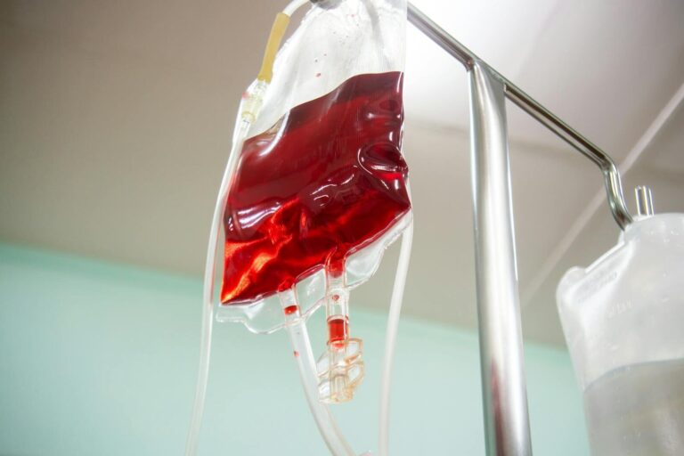 Blood bag connected to an IV line in a clinical setting, emphasizing healthcare and emergency treatment.