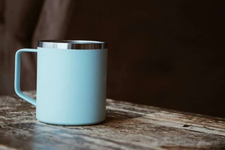 Light blue mug on a rustic wooden table, perfect for coffee or tea lovers.