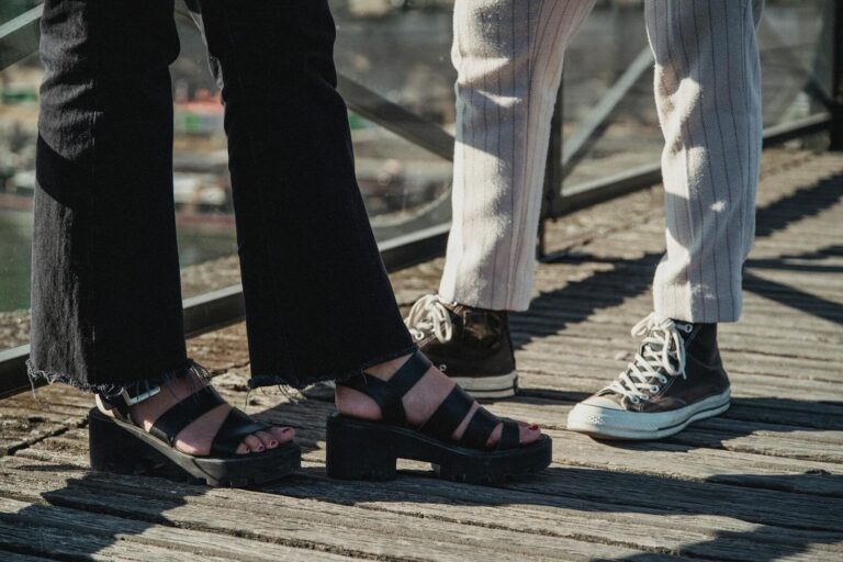 Stylish footwear on display outdoors, showcasing sandals and sneakers in a casual setting.
